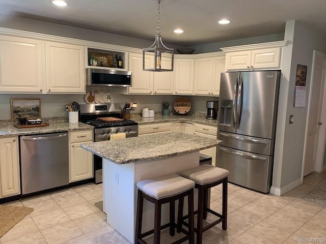 23287 Angel Park Dr, Macomb, MI 48042 - kitchen with stainless steel appliances, a breakfast bar area, recessed lighting, light tile patterned floors, and a kitchen island
