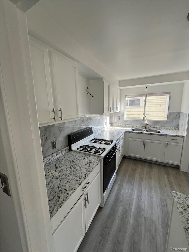 7800 Rutland St, Detroit, MI 48228 - kitchen with white gas range oven, white cabinets, and light stone counters