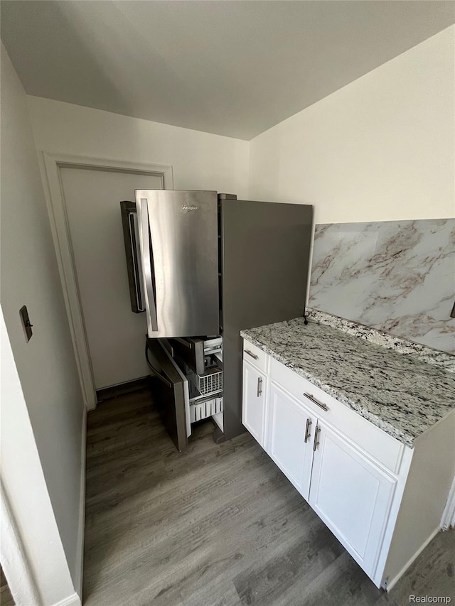 7800 Rutland St, Detroit, MI 48228 - kitchen featuring wood finished floors, white cabinets, freestanding refrigerator, and light stone countertops
