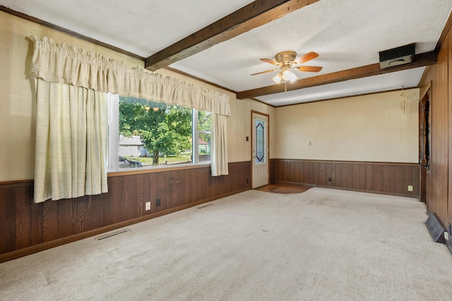 156 N Woodlawn Ave, Battle Creek, MI 49037 - spare room with beam ceiling, a wainscoted wall, wood walls, a ceiling fan, and carpet floors