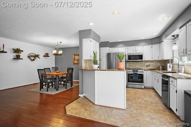 6559 Ridgeview Dr, Clarkston, MI 48346 - kitchen featuring stainless steel appliances, a chandelier, white cabinets, backsplash, and light wood finished floors