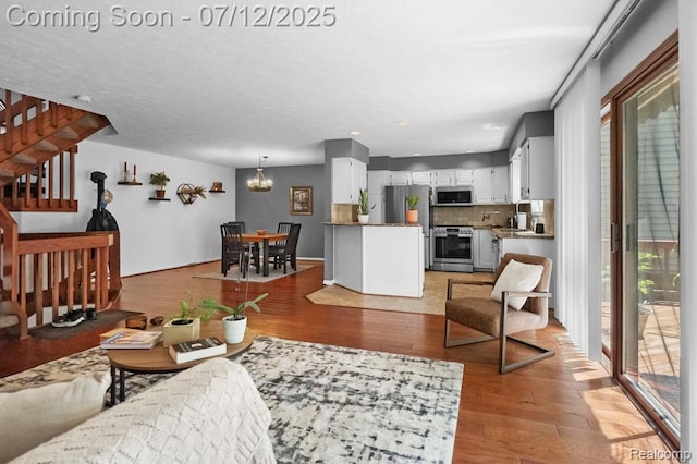 6559 Ridgeview Dr, Clarkston, MI 48346 - living area featuring stairs, light wood-style flooring, and a chandelier