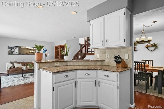 6559 Ridgeview Dr, Clarkston, MI 48346 - kitchen featuring dark wood finished floors, white cabinetry, dark stone counters, a peninsula, and a textured ceiling