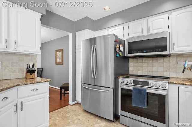 6559 Ridgeview Dr, Clarkston, MI 48346 - kitchen featuring appliances with stainless steel finishes, light stone counters, white cabinets, and decorative backsplash