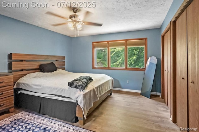 6559 Ridgeview Dr, Clarkston, MI 48346 - bedroom featuring light wood-style flooring, a closet, a textured ceiling, and ceiling fan