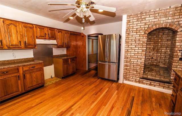 2380 Wilder Rd, Metamora, MI 48455 - kitchen with freestanding refrigerator, a ceiling fan, brown cabinetry, light wood-style flooring, and dark countertops