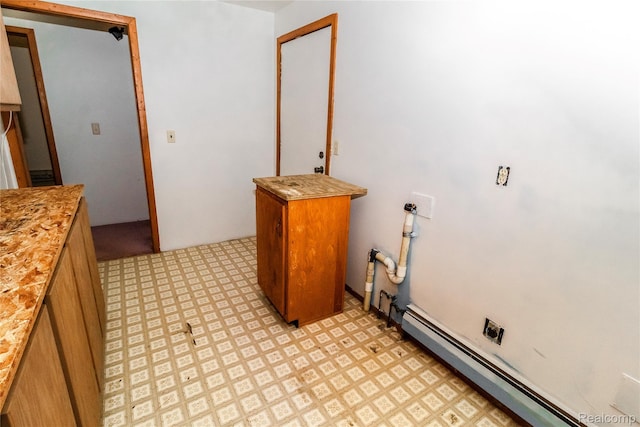 2380 Wilder Rd, Metamora, MI 48455 - laundry room featuring light flooring, a baseboard radiator, and cabinet space