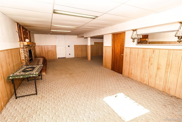 2380 Wilder Rd, Metamora, MI 48455 - unfurnished room featuring wainscoting, wood walls, a brick fireplace, carpet floors, and a paneled ceiling