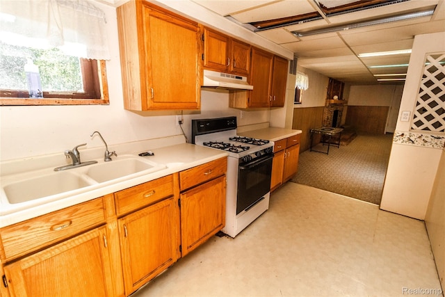 2380 Wilder Rd, Metamora, MI 48455 - kitchen featuring light floors, gas range, light countertops, under cabinet range hood, and brown cabinets
