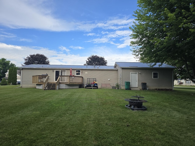 274 Pioneer St, Mendon, MI 49072 - rear view of property featuring a deck, a yard, a fire pit, and a metal roof