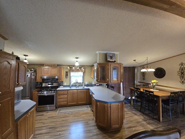 274 Pioneer St, Mendon, MI 49072 - kitchen with stainless steel gas range oven, dark wood-style flooring, a peninsula, a textured ceiling, and a chandelier