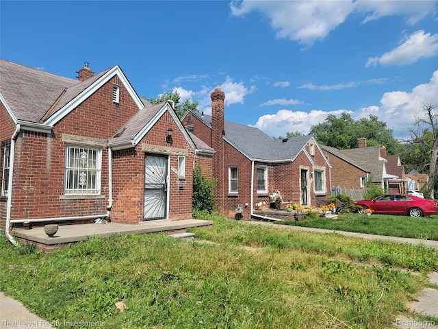 8850 Farmbrook St, Detroit, MI 48236 - view of front of property with brick siding, a chimney, and a front yard