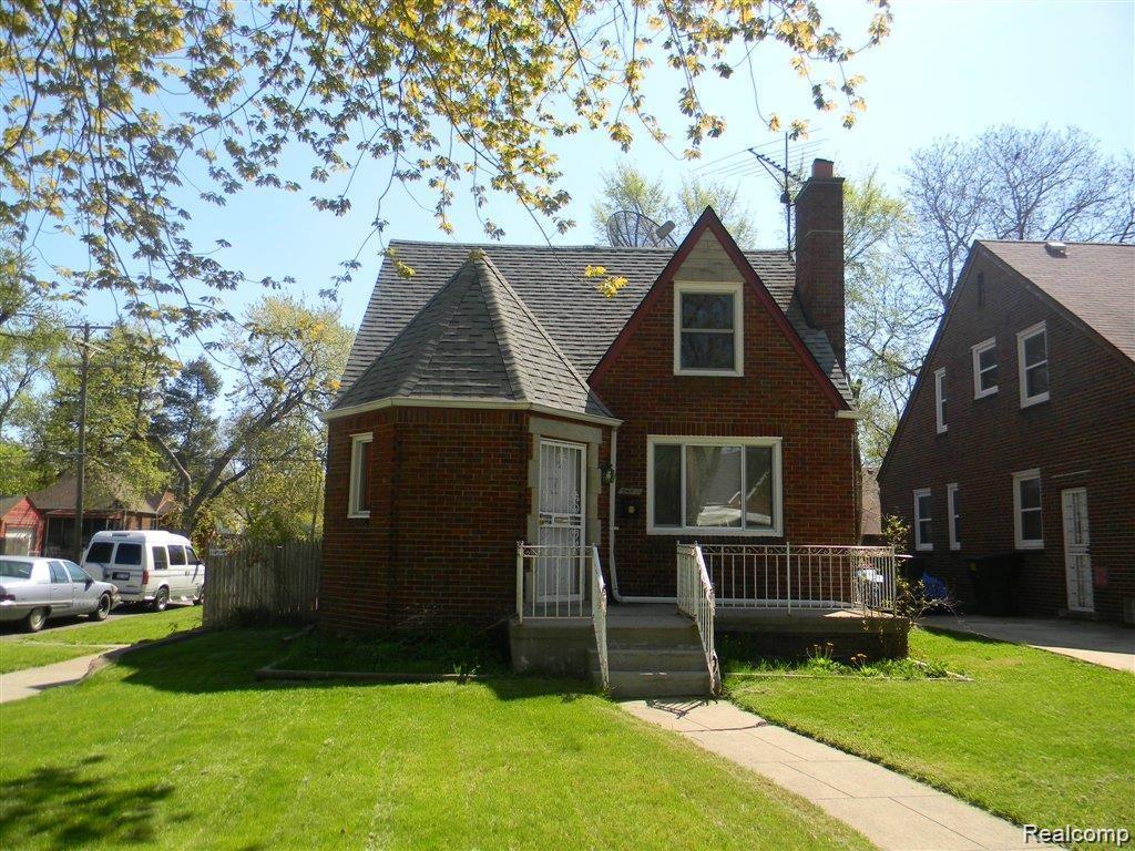 15376 Prest St, Detroit, MI 48227 - tudor home featuring a front yard, brick siding, a chimney, and roof with shingles