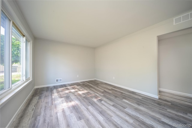 6448 Hunter Ct, Westland, MI 48185 - empty room with healthy amount of natural light, wood finished floors, and crown molding