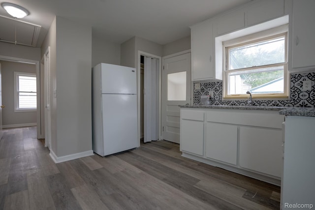 23199 Stewart Ave, Warren, MI 48089 - kitchen featuring freestanding refrigerator, light wood finished floors, white cabinets, and light stone countertops