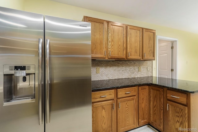 21433 Archwood Cir, Farmington Hills, MI 48336 - kitchen with stainless steel refrigerator with ice dispenser, brown cabinetry, tasteful backsplash, dark stone countertops, and a peninsula