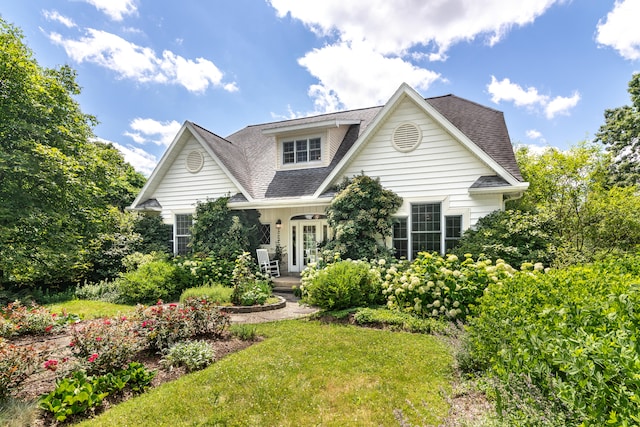 8150 Mester Rd, Chelsea, MI 48118 - view of front of house with roof with shingles, covered porch, and a front lawn