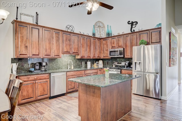 4361 Bennett Park Cir, Troy, MI 48085 - kitchen featuring appliances with stainless steel finishes, a towering ceiling, ceiling fan, dark stone countertops, and backsplash