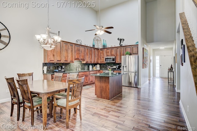 4361 Bennett Park Cir, Troy, MI 48085 - dining space featuring a towering ceiling, ceiling fan, light wood-style floors, and a chandelier