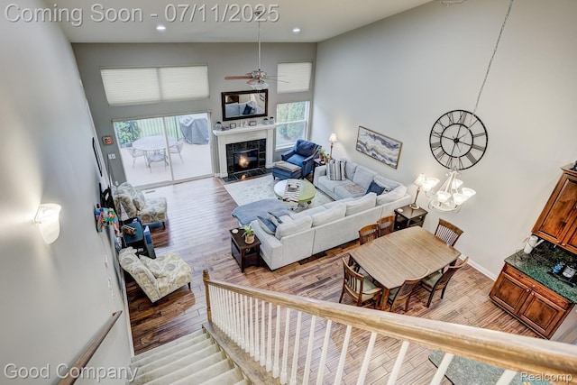 4361 Bennett Park Cir, Troy, MI 48085 - living area with light wood-style floors, ceiling fan, a premium fireplace, a towering ceiling, and recessed lighting