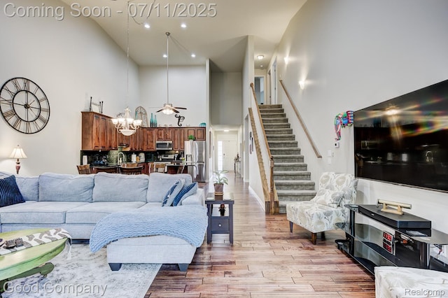 4361 Bennett Park Cir, Troy, MI 48085 - living area featuring a high ceiling, stairway, light wood finished floors, a chandelier, and recessed lighting
