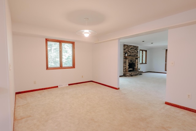 18400 N Fruitport Rd, Spring Lake, MI 49456 - spare room with light carpet and a fireplace