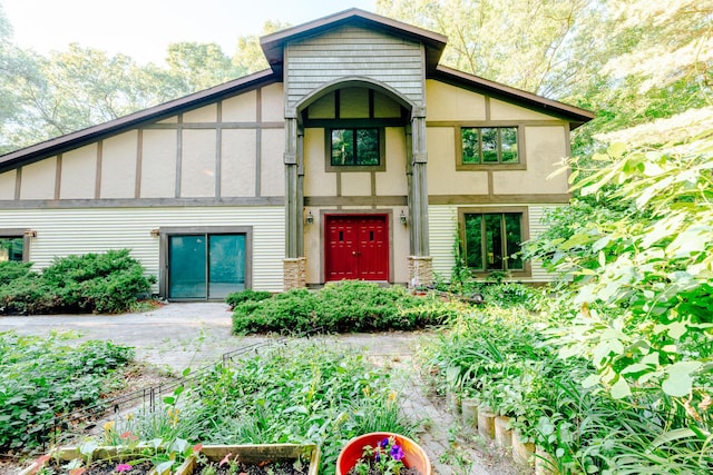 18400 N Fruitport Rd, Spring Lake, MI 49456 - tudor house with stucco siding and a vegetable garden