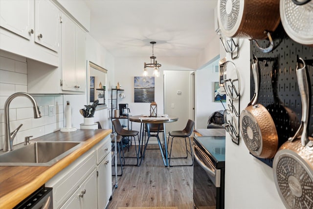 32708 Harper Ave Unit 5, Saint Clair Shores, MI 48082 - kitchen with electric range, light wood finished floors, white cabinetry, backsplash, and dishwasher