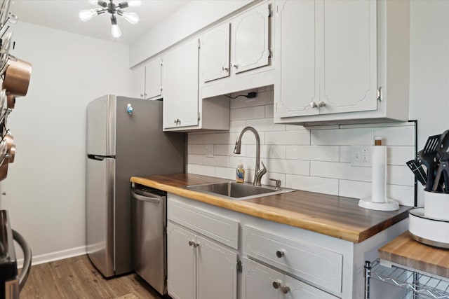 32708 Harper Ave Unit 5, Saint Clair Shores, MI 48082 - kitchen featuring stainless steel appliances, decorative backsplash, dark wood-style floors, and butcher block counters