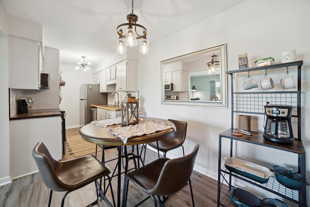 32708 Harper Ave Unit 5, Saint Clair Shores, MI 48082 - dining area with wood finished floors and a chandelier