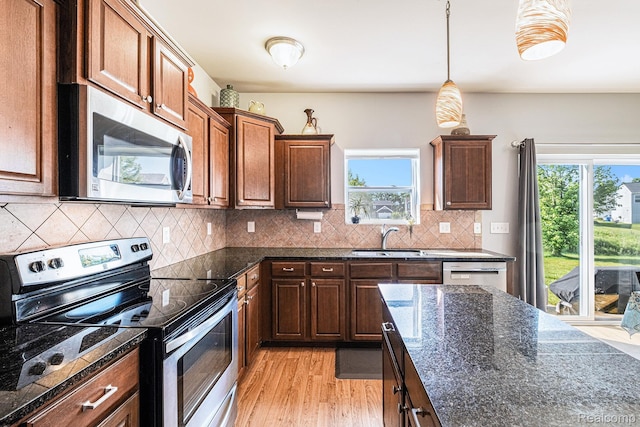 16621 Charles Town Ct, Linden, MI 48451 - kitchen with stainless steel appliances, light wood-type flooring, healthy amount of natural light, and dark stone counters