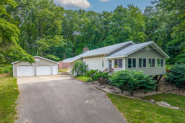 23974 Hooker Dr, Sand Lake, MI 49343 - ranch-style home with an outbuilding, a detached garage, a chimney, and a shingled roof