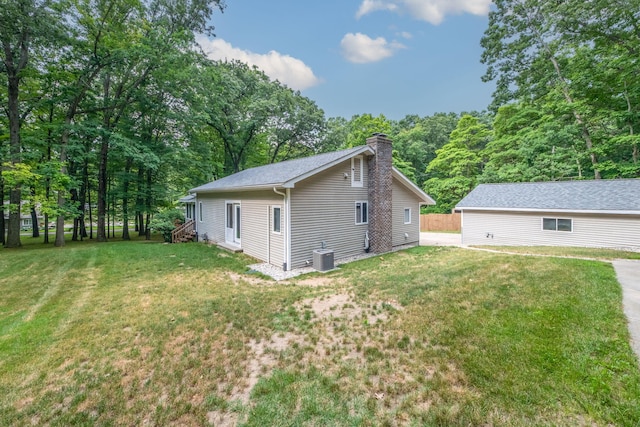 23974 Hooker Dr, Sand Lake, MI 49343 - back of property with a chimney and a lawn