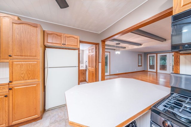 23974 Hooker Dr, Sand Lake, MI 49343 - kitchen with freestanding refrigerator, stainless steel gas stove, black microwave, ceiling fan, and beamed ceiling
