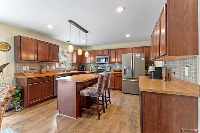 14236 Marshall Dr, Redford, MI 48239 - kitchen with appliances with stainless steel finishes, a kitchen breakfast bar, tasteful backsplash, light wood finished floors, and recessed lighting