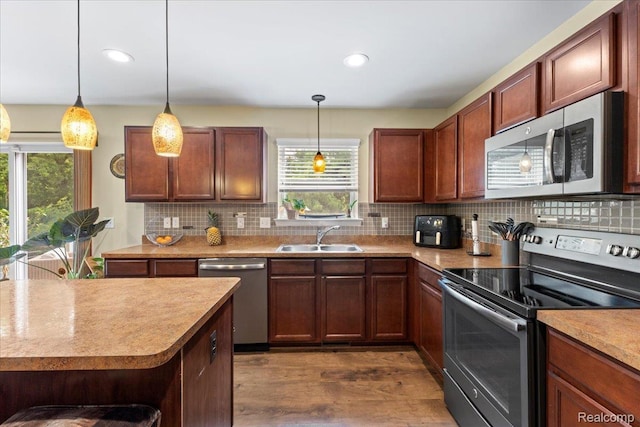 14236 Marshall Dr, Redford, MI 48239 - kitchen featuring appliances with stainless steel finishes, plenty of natural light, dark wood finished floors, decorative backsplash, and recessed lighting