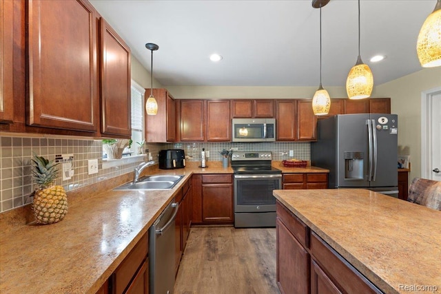 14236 Marshall Dr, Redford, MI 48239 - kitchen with stainless steel appliances, light countertops, pendant lighting, wood finished floors, and decorative backsplash