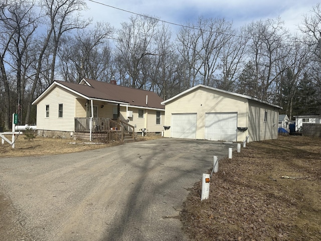 8942 28th Ave, Bitely, MI 49309 - view of front facade featuring an outbuilding, a garage, asphalt driveway, and a chimney