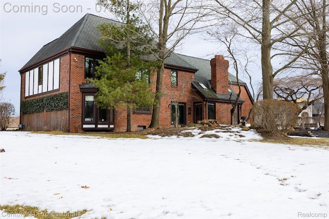 1180 Knob Creek Dr, Rochester, MI 48306 - snow covered property featuring brick siding, a chimney, and roof with shingles