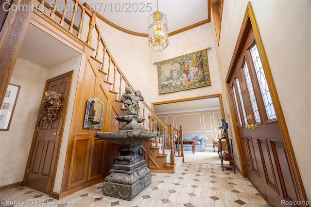 1180 Knob Creek Dr, Rochester, MI 48306 - foyer entrance with a decorative wall, stairs, a towering ceiling, ornamental molding, and a chandelier