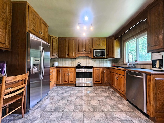 3374 Elmwood St, Clio, MI 48420 - kitchen with stainless steel appliances, decorative backsplash, dark countertops, stone finish floors, and brown cabinets