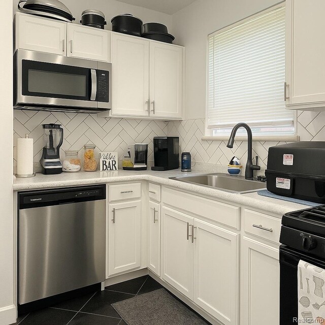13516 Mansfield St, Detroit, MI 48227 - kitchen with appliances with stainless steel finishes, white cabinets, and dark tile patterned floors