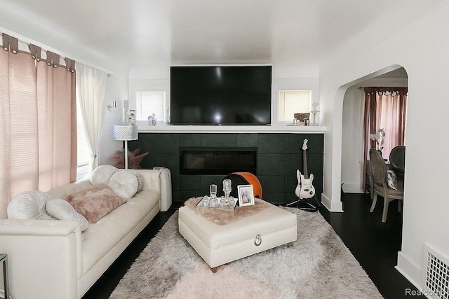 13516 Mansfield St, Detroit, MI 48227 - living area with arched walkways, a tiled fireplace, and wood finished floors