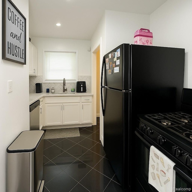 13516 Mansfield St, Detroit, MI 48227 - kitchen featuring black appliances, white cabinets, light countertops, dark tile patterned floors, and decorative backsplash