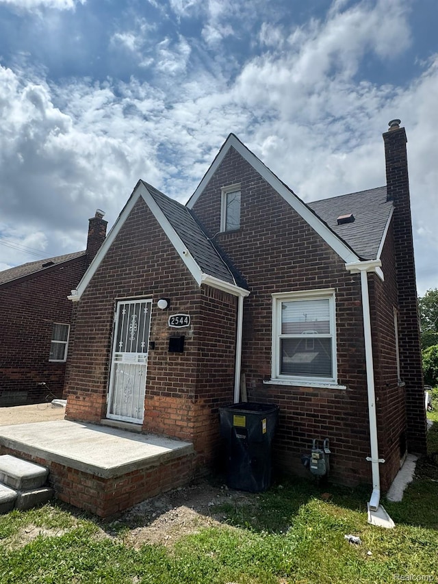 2544 S Beatrice St, Detroit, MI 48217 - back of house with a chimney, brick siding, roof with shingles, and a patio