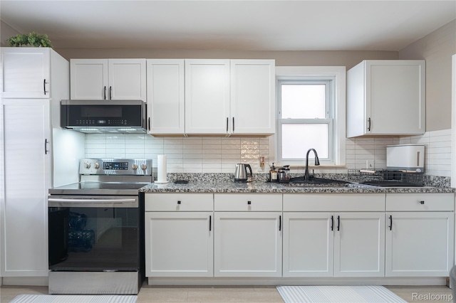 2544 S Beatrice St, Detroit, MI 48217 - kitchen featuring stainless steel range with electric cooktop, stone counters, white cabinetry, and backsplash