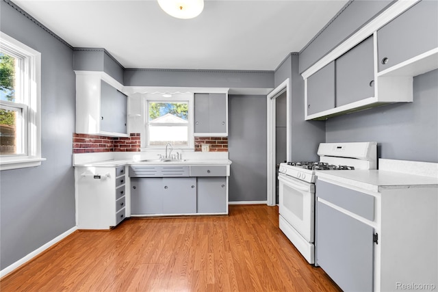 22610 Karam Ct, Macomb, MI 48091 - kitchen featuring white range with gas stovetop, light countertops, light wood finished floors, backsplash, and gray cabinets