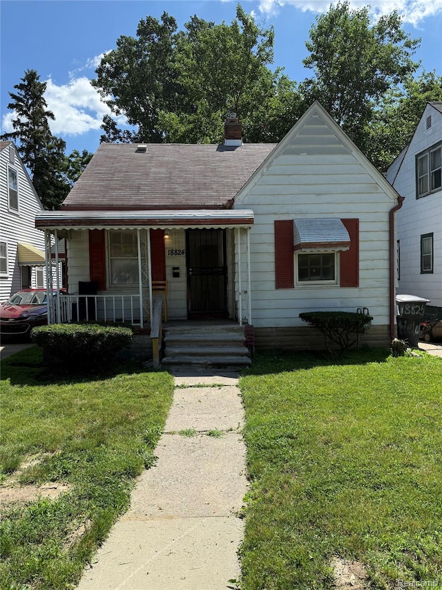 18824 Helen St, Detroit, MI 48234 - bungalow featuring covered porch, a front yard, and a chimney