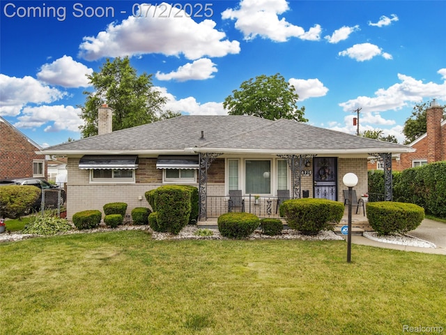 4910 Julius Blvd, Westland, MI 48186 - view of front of home featuring brick siding, a front lawn, a chimney, a shingled roof, and covered porch