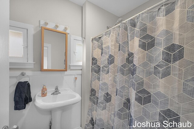 908 Chatham St NW, Grand Rapids, MI 49504 - bathroom featuring a shower with shower curtain and tile walls
